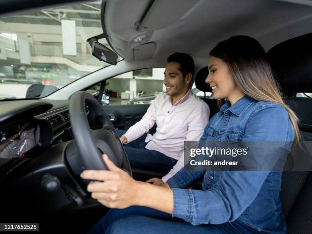 woman talking to a salesman at the dealership before taking a car for a test drive - test drive stock pictures, royalty-free photos & images