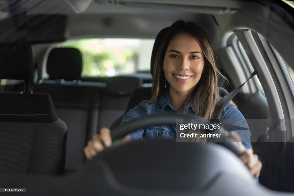 Retrato de uma mulher parecendo muito feliz dirigindo um carro