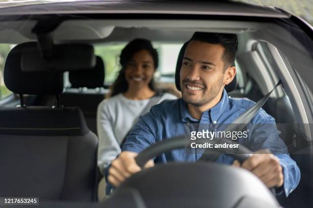 glücklicher fahrer transportiert eine frau im auto - taxi fahrgemeinschaft stock-fotos und bilder