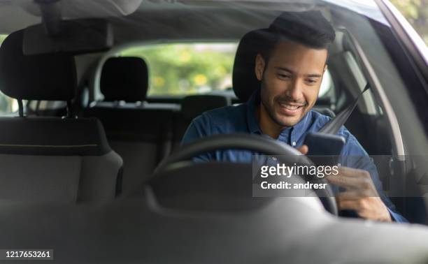 glücklicher mann sms und fahren in seinem auto - auto navigation stock-fotos und bilder