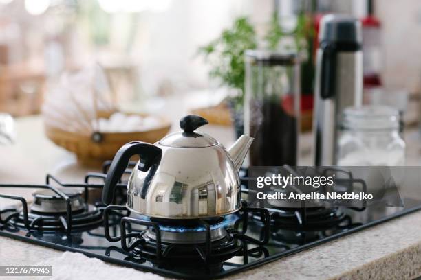 kettle on, utensils for making coffee in the background - ketel stockfoto's en -beelden