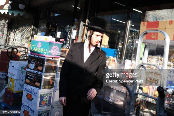 Orthodox jews walk through the Borough Park neighborhood on the eve of the Passover holiday on April 08, 2020 in New York City. Borough Park, a...