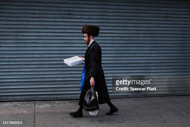 An Orthodox jewish man walks through the Borough Park neighborhood on the eve of the Passover holiday on April 08, 2020 in New York City. Borough...