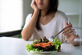 Unhappy women is on dieting time, girl do not want to eat vegetables.
