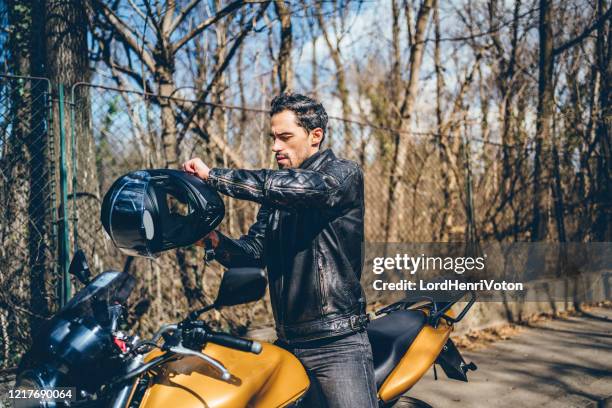 мужчина в кожаной куртке возле мотоцикла