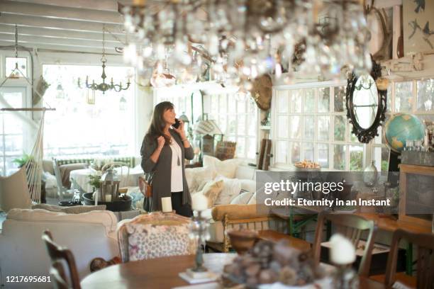 mature woman shopping in an antique store - antique phone fotografías e imágenes de stock