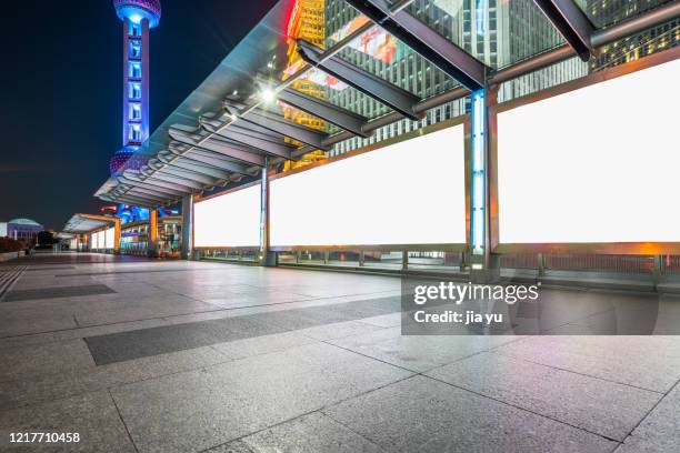 billboards on sidewalks in lujiazui financial district, pudong, shanghai. night. - shanghai night stock-fotos und bilder