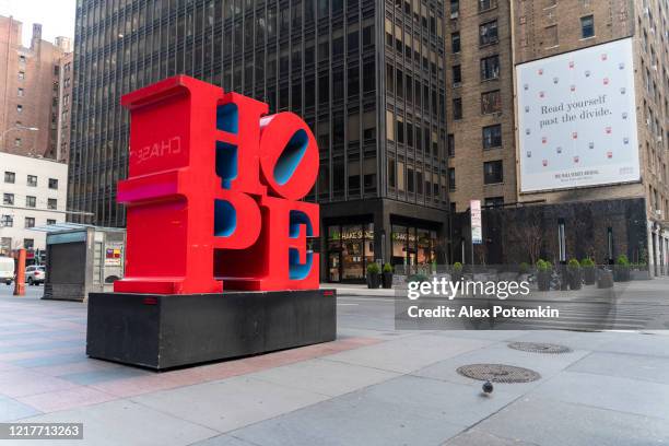 hope sculptuur van robert indiana op de straten van midtown manhattan brengt hoop aan new yorkers 'geesten en harten. - 7th avenue stockfoto's en -beelden