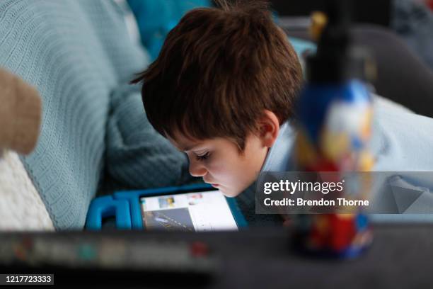 Phoenix Crawford takes a break from home-schooling by watching content on an iPad on April 09, 2020 in Sydney, Australia. Massage therapist and...