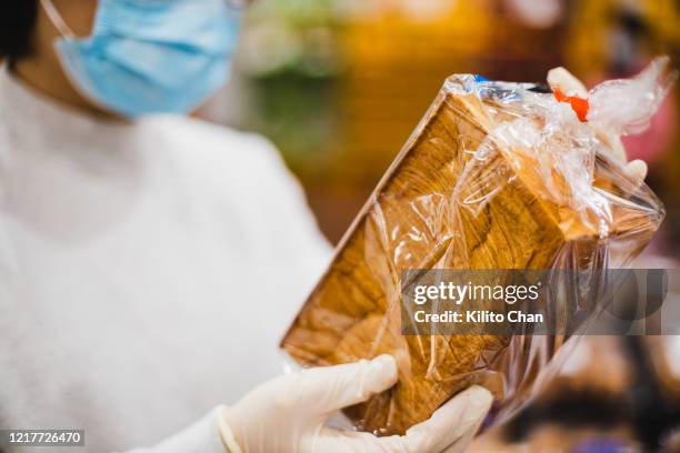 asian female wearing a face mask shopping at a supermarket - bread packet stock pictures, royalty-free photos & images