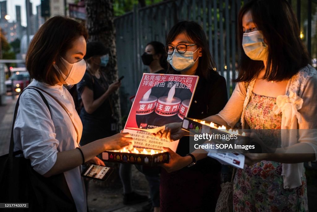 Pro-democracy protesters distribute electric candles before...