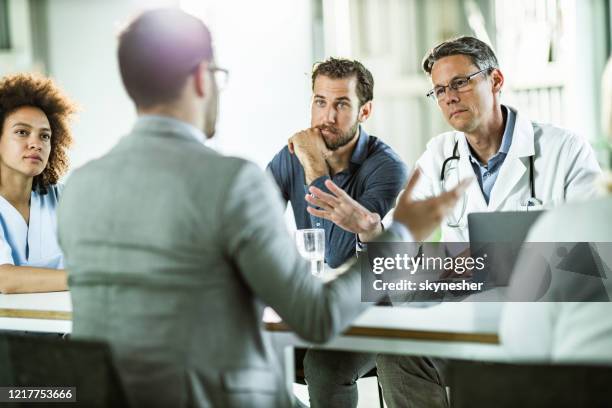 medical experts and businessmen having a meeting in the office. - doctor recruitment stock pictures, royalty-free photos & images