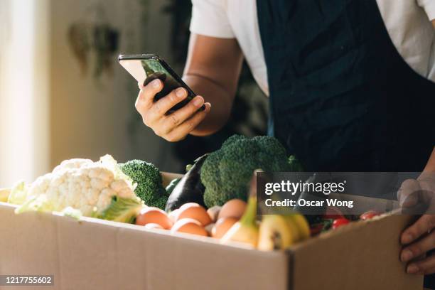 man ordering fresh food delivery with mobile phone - grocery delivery stock pictures, royalty-free photos & images