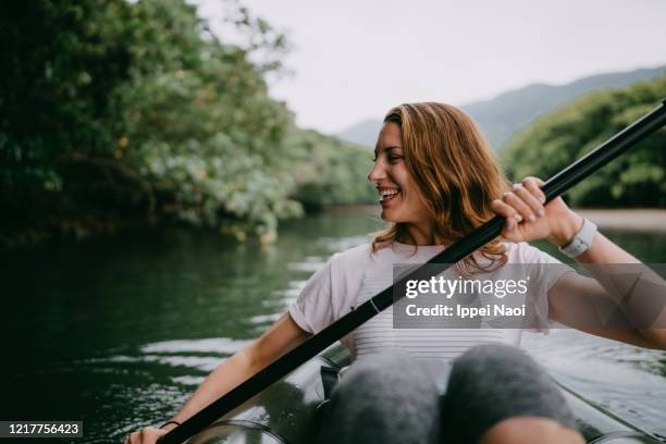 woman paddling kayak in mangrove river, iriomote island, japan - kayaker woman stock-fotos und bilder