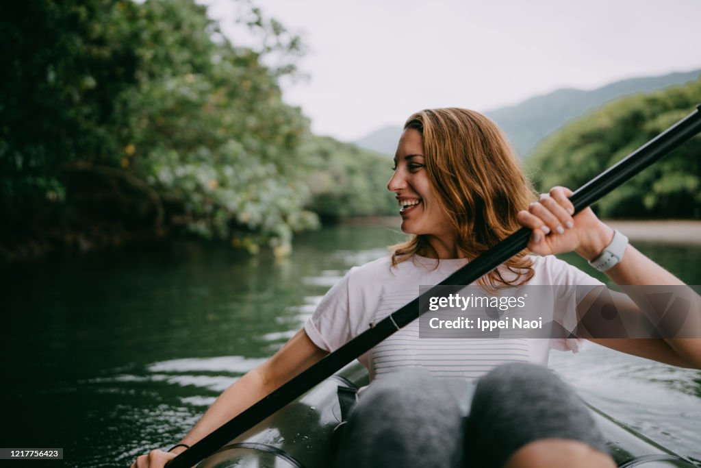 Woman paddling kayak in mangrove river, Iriomote Island, Japan