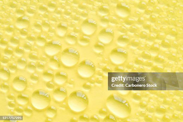 drops on yellow background - yellow construction paper texture stock pictures, royalty-free photos & images