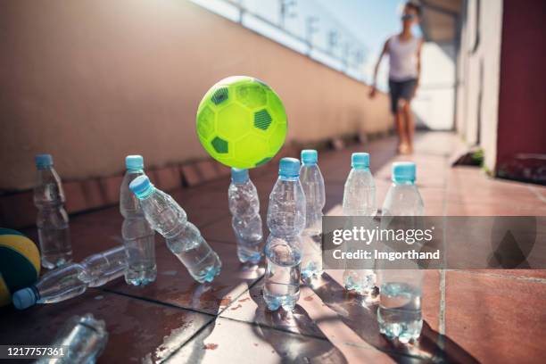 jonge geitjes die ad hoc kegelen op balkon spelen - provisorisch stockfoto's en -beelden