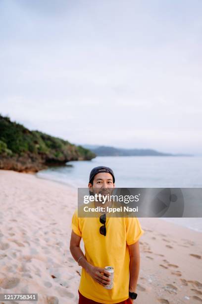 man on tropical beach at sunset, iriomote island, okinawa, japan - beer can island stock pictures, royalty-free photos & images
