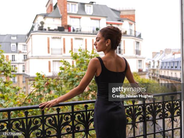 stylish young women on her balcony in paris france, daytime - paris balcony stock pictures, royalty-free photos & images