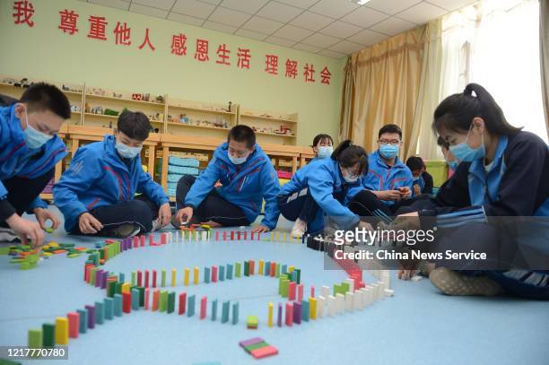Students of Hohhot No.26 Middle School play dominoes during a mental health course to relieve stress on April 9, 2020 in Hohhot, Inner Mongolia...