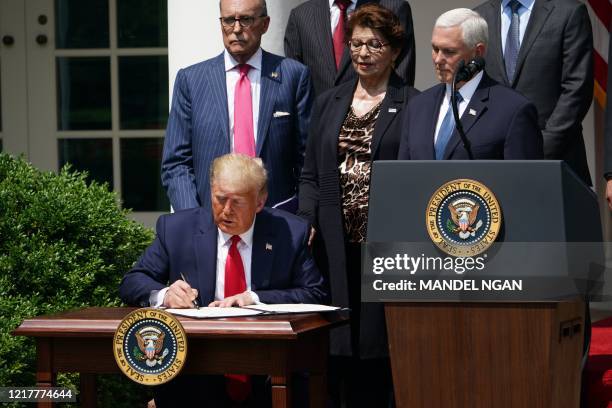 President Donald Trump signs the Paycheck Protection Program Flexibility Act of 2020 as he holds a press conference on the economy, in the Rose...