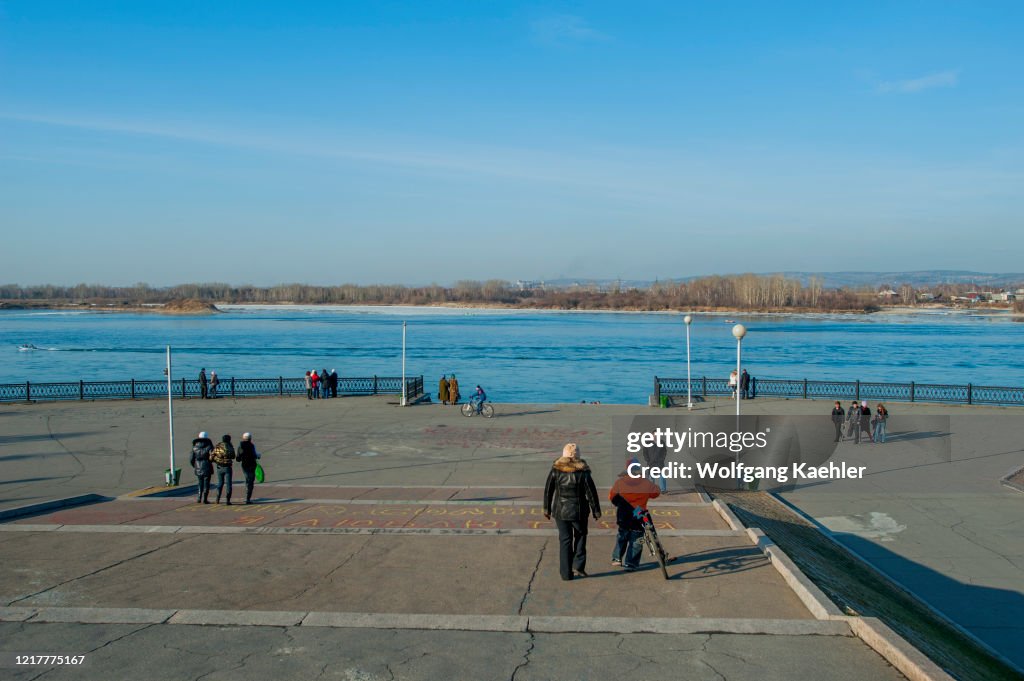 People walking on the promenade of the Angara River in...