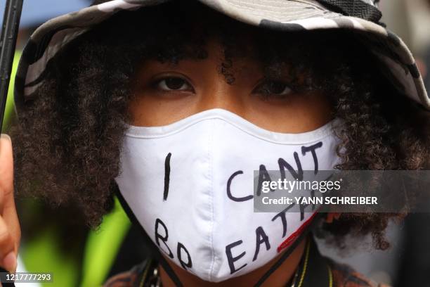 Protestor wears a face mask reading "I can't breathe" in Frankfurt am Main, western Germany on June 5, 2020 during a rally in solidarity with...