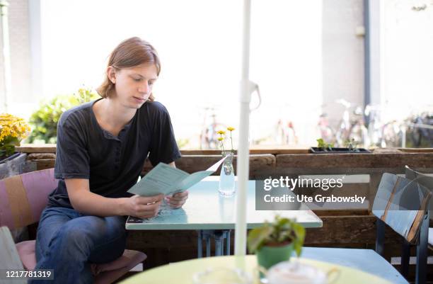 In this photo illustration a young man is taking his decision in a tiny cafe on May 29, 2020 in Bonn, Germany.