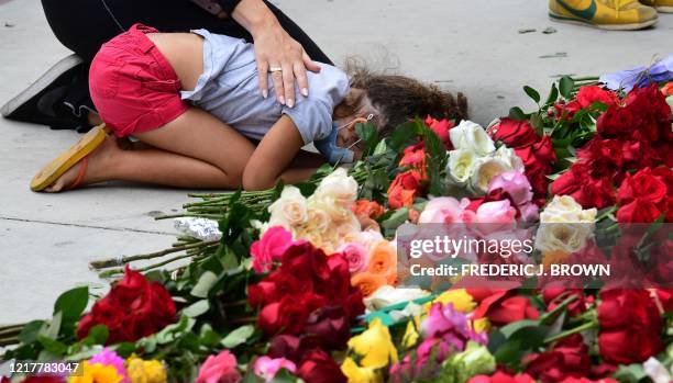 Child is consoled while grieving as protesters gather to place roses in front of the Hall of Justice in Los Angeles, California, on June 5, 2020 in...