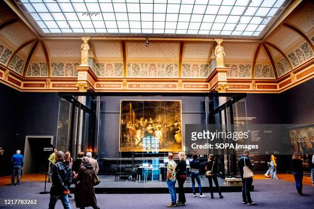 People viewing paintings by Rembrandt at the museum during the reopening. The Rijksmuseum, Dutch museum reopens under new measures to prevent the...
