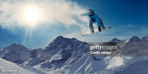 extreme snowboarder in massive big air jump in snowy mountains - snowboardfahren stock-fotos und bilder