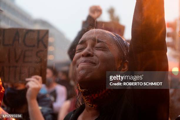 Protester participates in a demonstration during a rain storm in front of Lafayette Park next to the White House, Washington, DC on June 5, 2020. -...