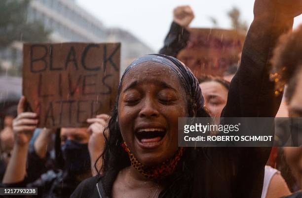 Protester shouts "Black Lives Matter" during a rain storm in front of Lafayette Park next to the White House, Washington, DC on June 5, 2020....