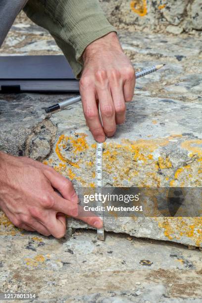 man measuring stones, phaistos, crete, greece - archeoloog stockfoto's en -beelden