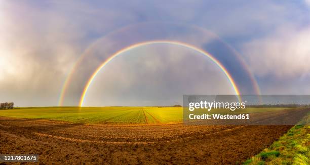 uk, scotland, panorama of double rainbow over agricultural field - arco iris doble fotografías e imágenes de stock