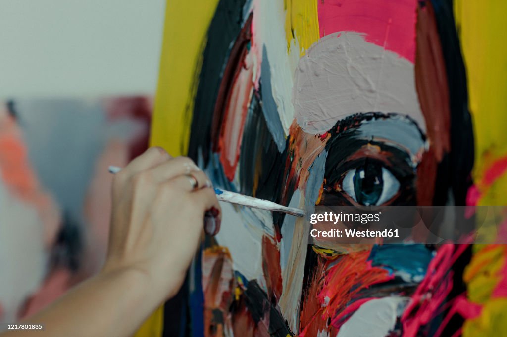 Hand of a female painter painting in her studio