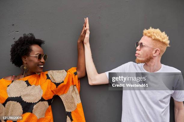 couple joining hands in front of grey background - white skin stock pictures, royalty-free photos & images