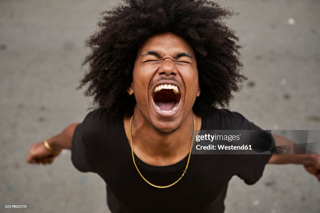 Portrait of screaming young man with afro