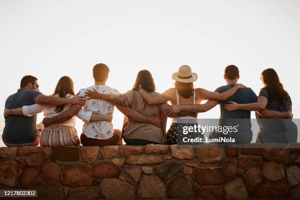 we're not just friends, we're one big family - arm around friend back stock pictures, royalty-free photos & images