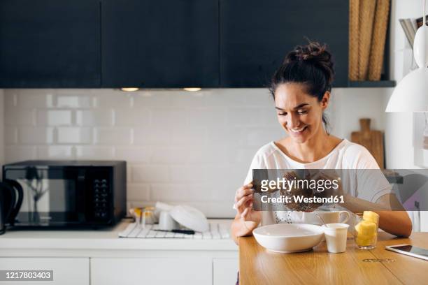 happy young woman having breakfast in kitchen - table of content stock pictures, royalty-free photos & images