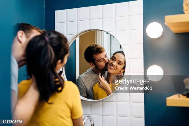 affectionate young couple in bathroom at home - couple and kiss and bathroom stock-fotos und bilder