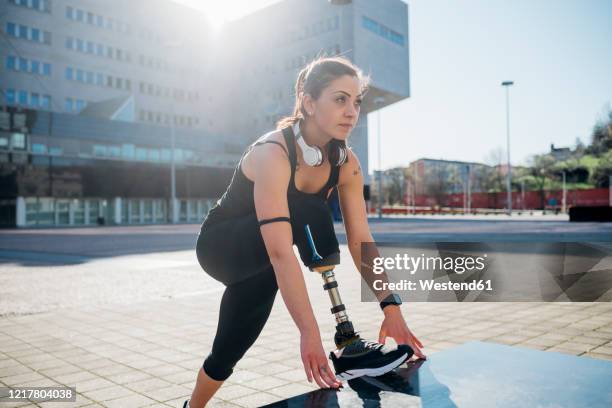 portrait of sporty young woman with leg prosthesis in the city - prosthetic stock-fotos und bilder