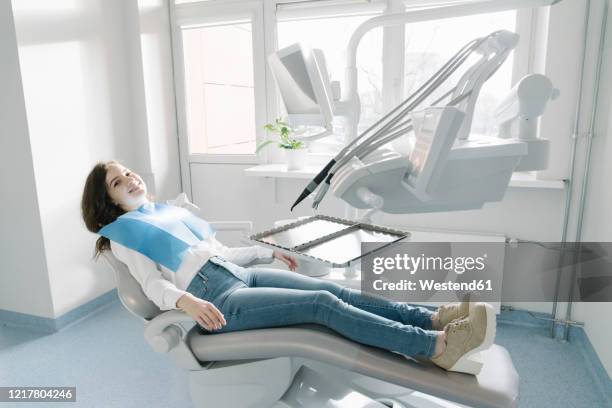 confident young woman waiting for treatment in dental clinic - zahnarztstuhl stock-fotos und bilder