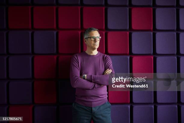 businessman standing at a noise reduction wall in office - tre quarti foto e immagini stock