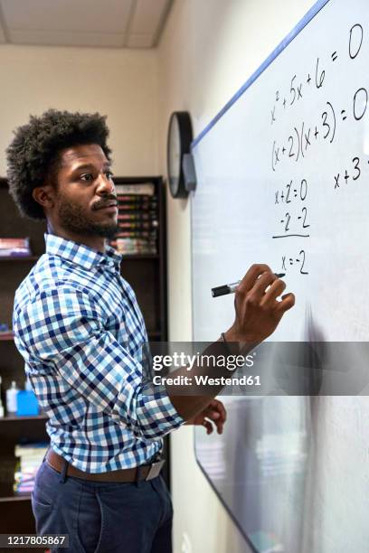 maths teacher writing a formula on a whiteboard - mathematician stock pictures, royalty-free photos & images
