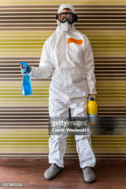 woman wearing protective clothes, sanitizing her home - 防護服 個照片及圖片檔