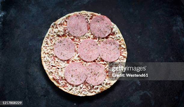 frozen pizza with salami and grated cheese - frozen man stock-fotos und bilder