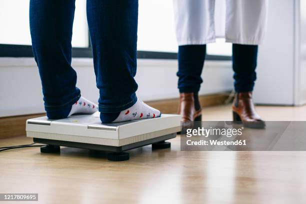 close-up ofwoman on scales in medical practice - legs in stockings stock pictures, royalty-free photos & images