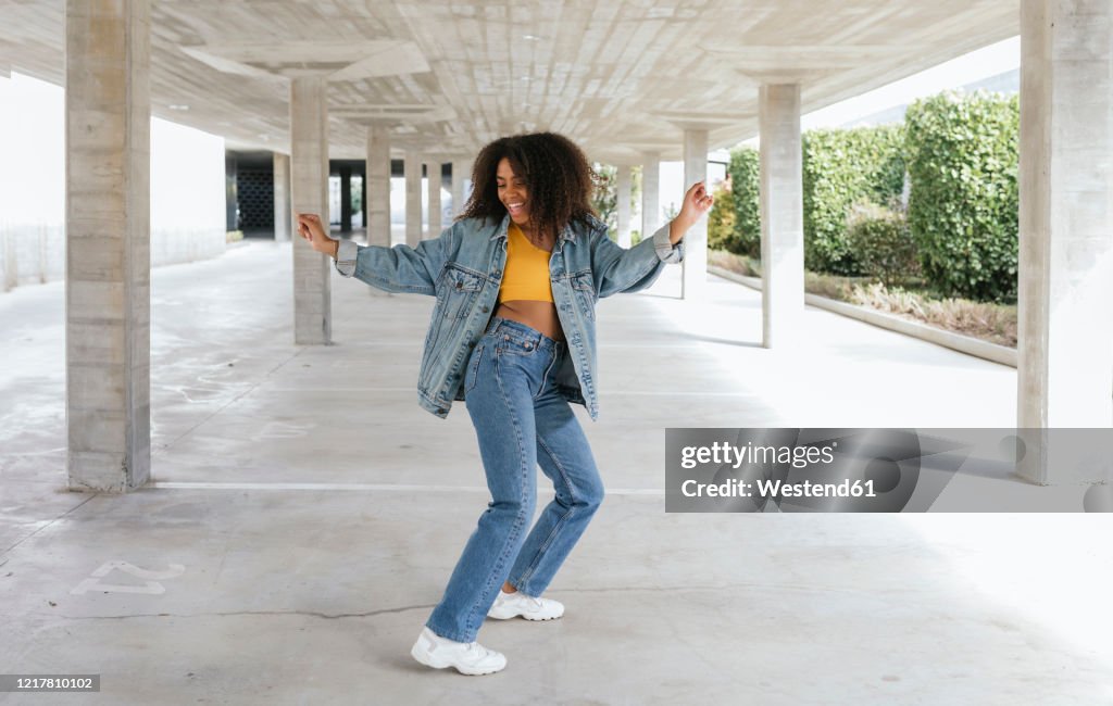 Smiling woman dancing in an empty parking