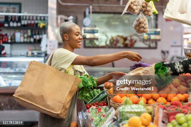 woman buying groceries in a market hall - grocery store produce stock pictures, royalty-free photos & images